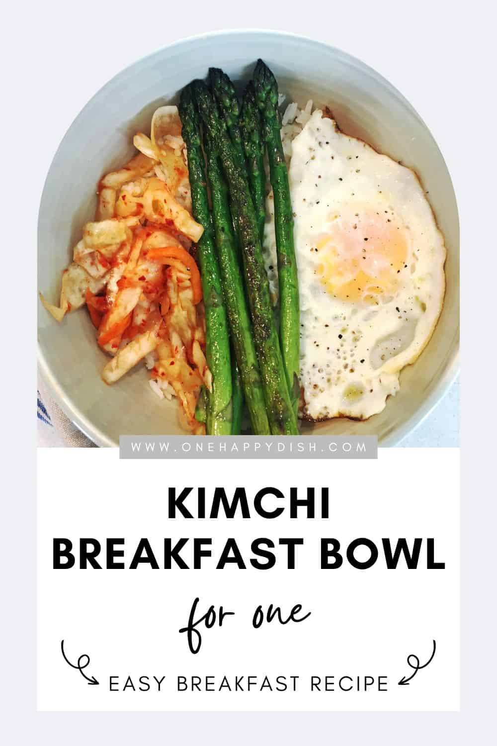 Kimchi breakfast bowl with asparagus and eggs in an off-white ceramic bowl.
