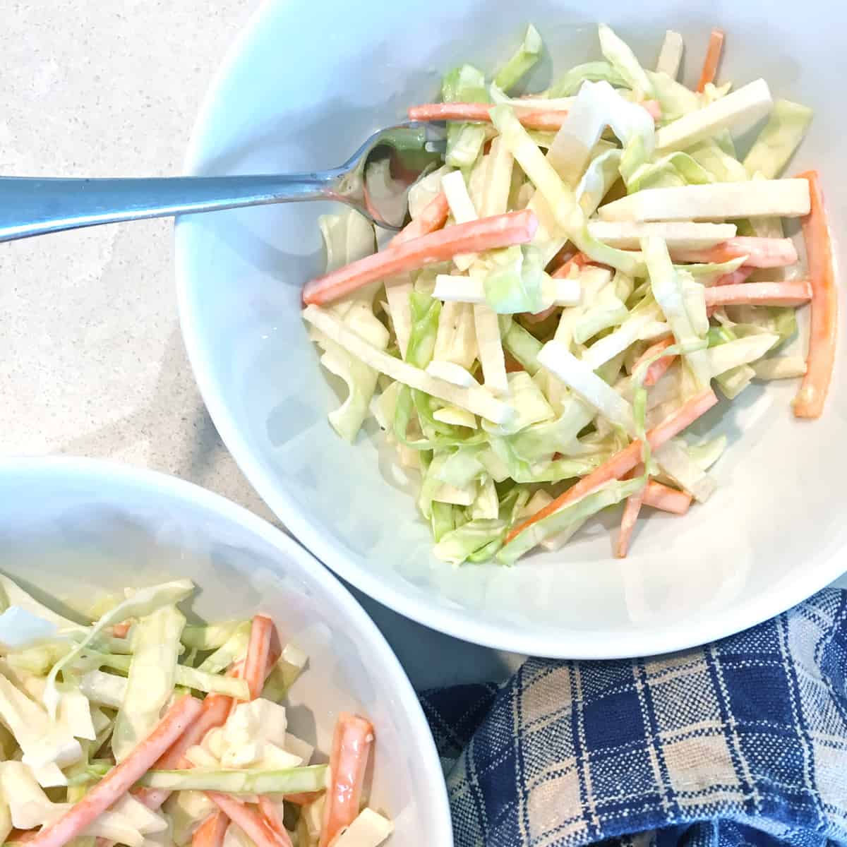 Simple jicama slaw in two small white salad bowls.