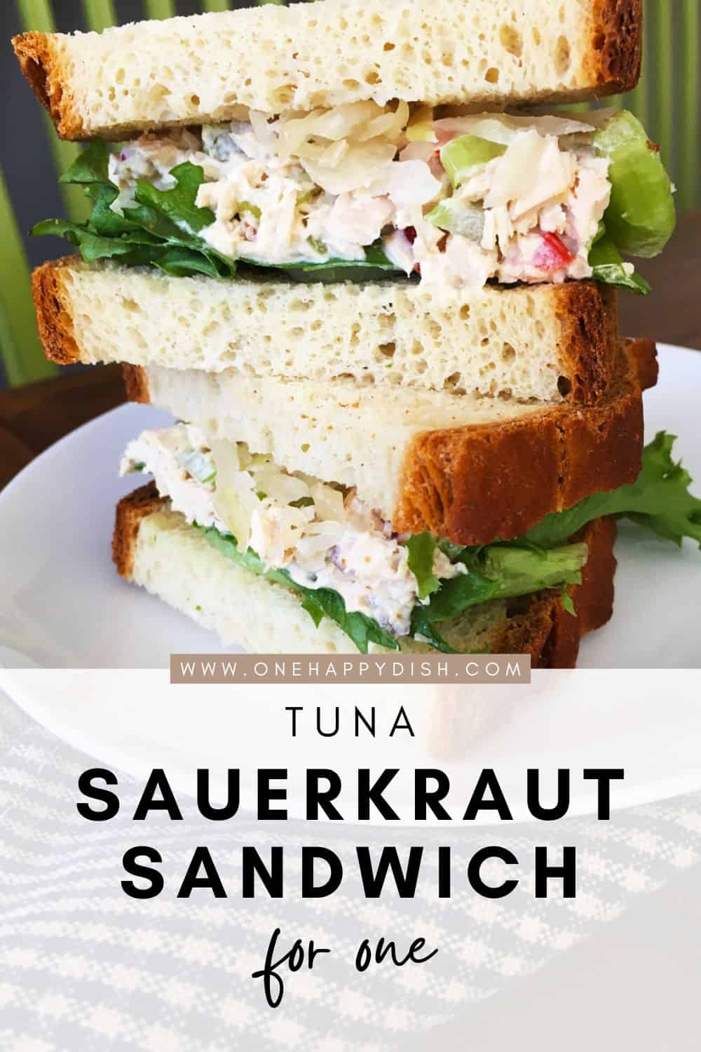 Tuna salad and sauerkraut sandwich on a white plate.