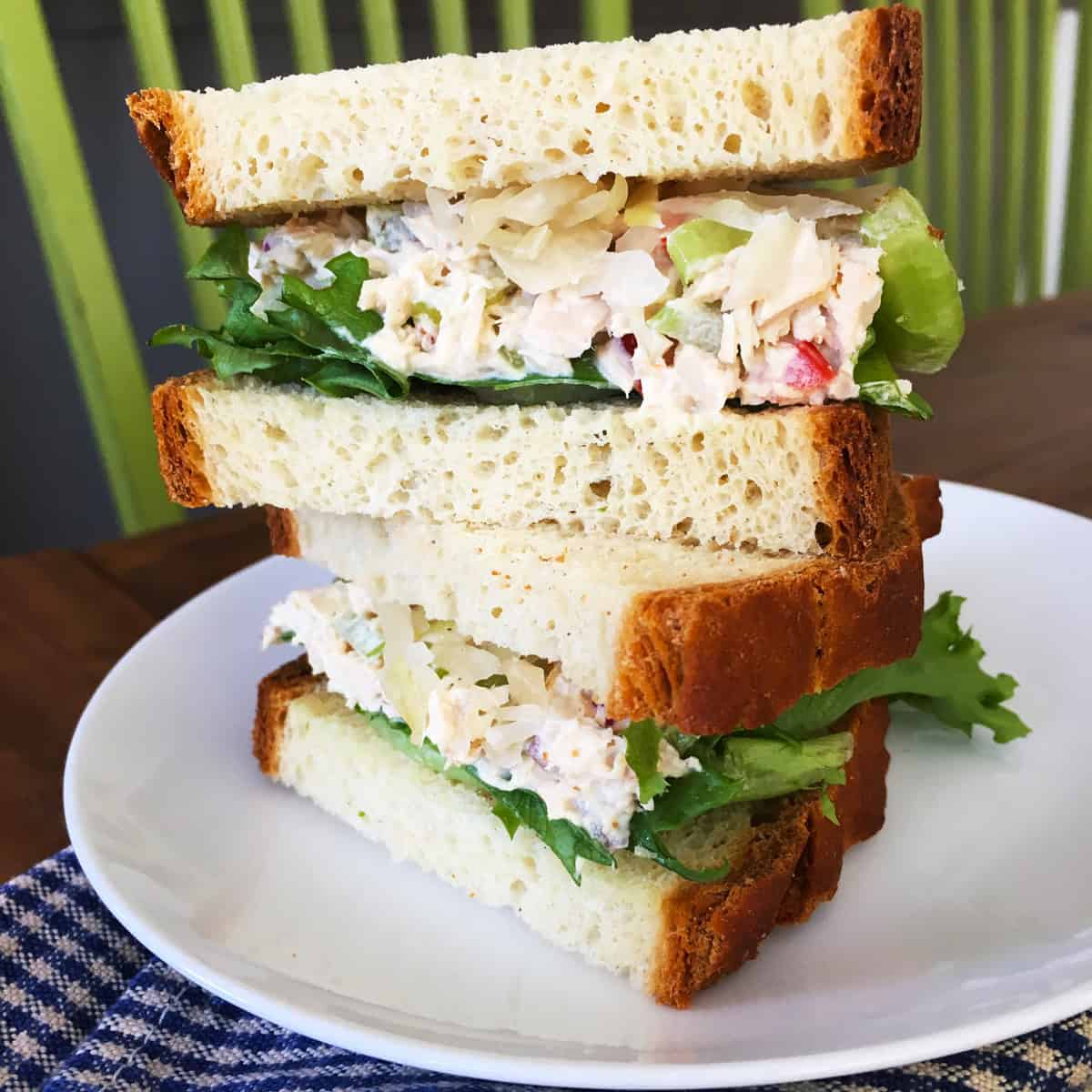 Tuna salad and sauerkraut sandwich on a white plate.