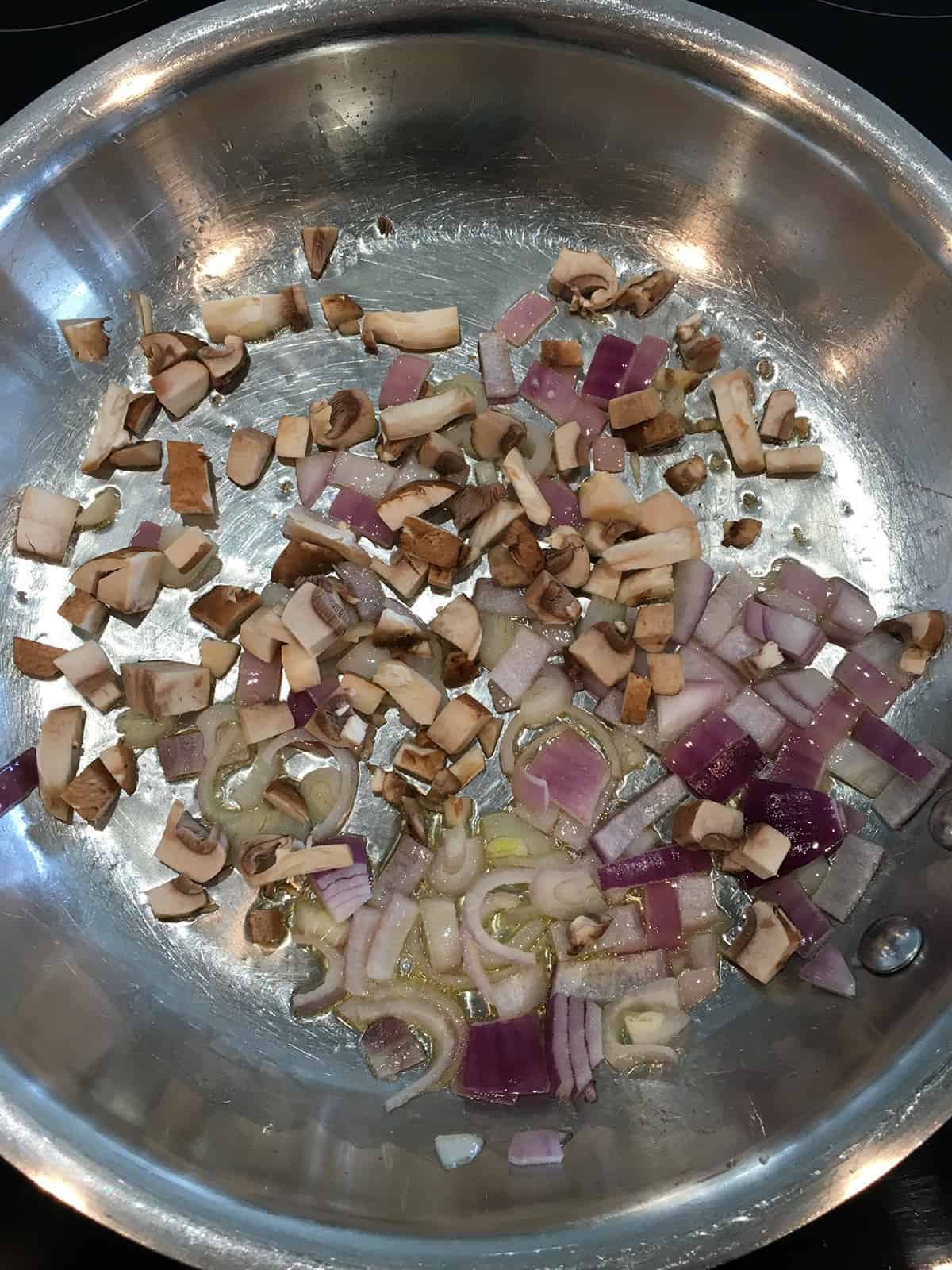 Sautéing onions, shallots and mushrooms with ghee in a stainless steel skillet