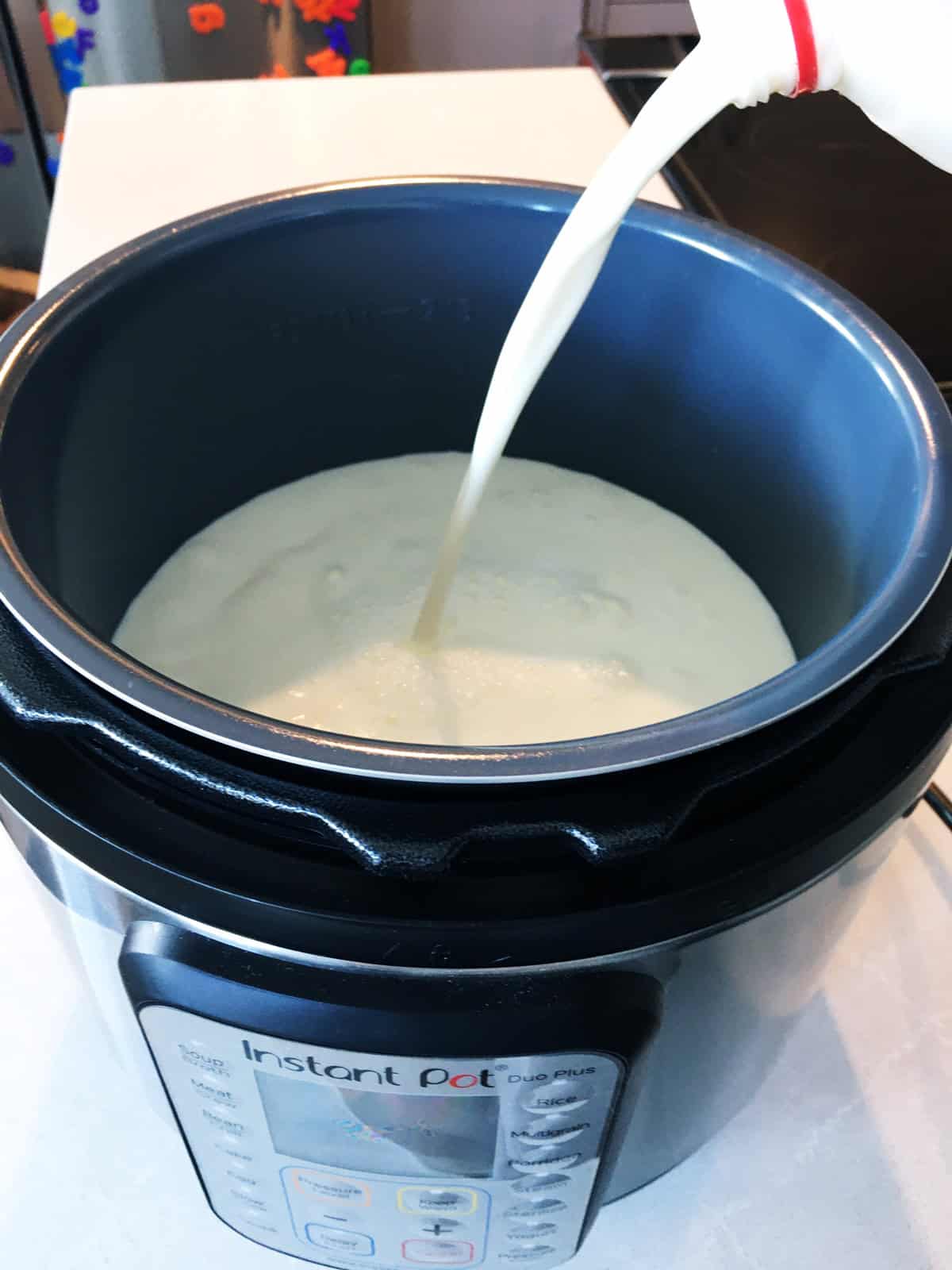 Pouring milk into an Instant Pot to make homemade yogurt