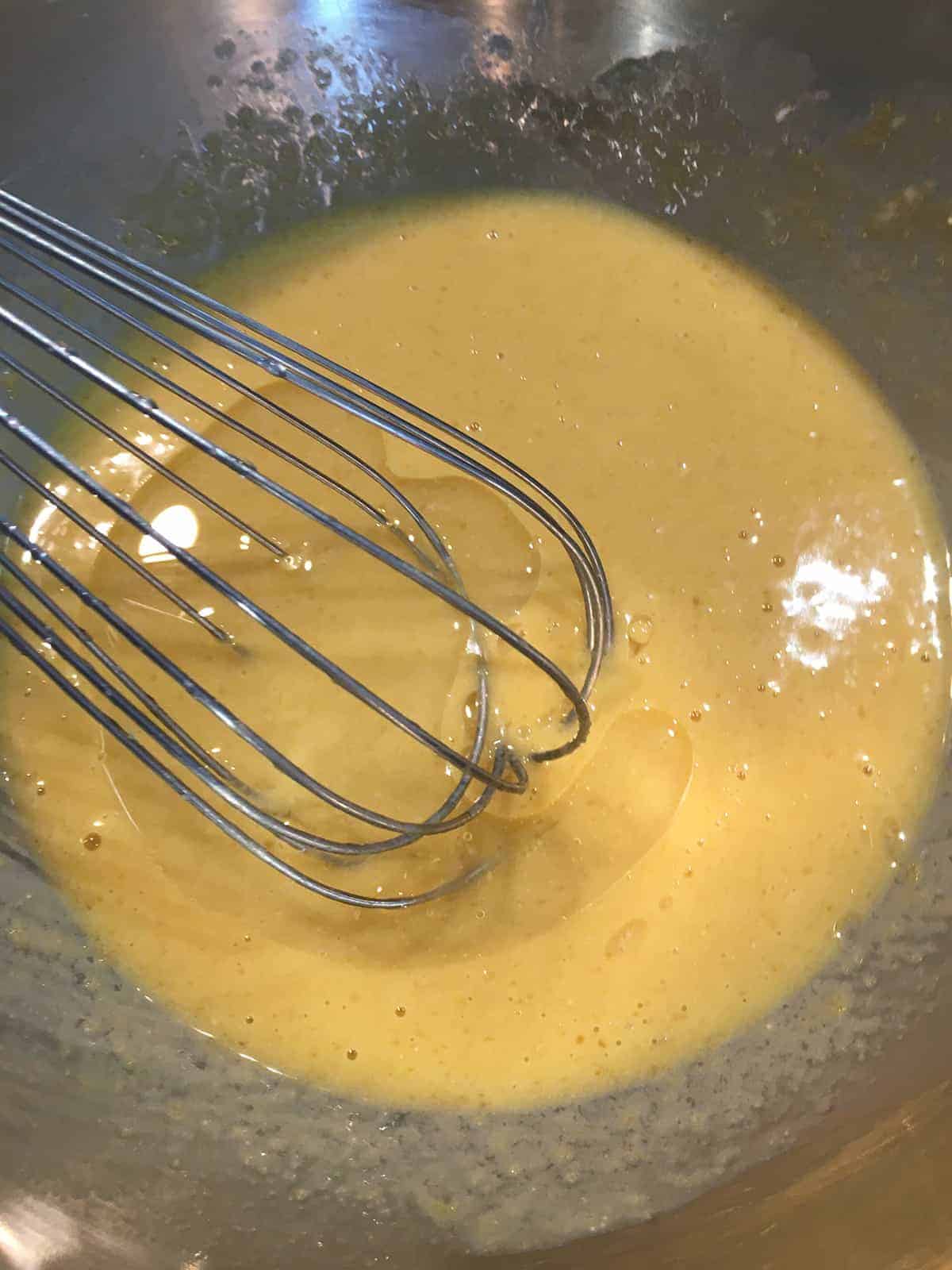 Whisking eggs, vanilla and coconut oil together for banana bread
