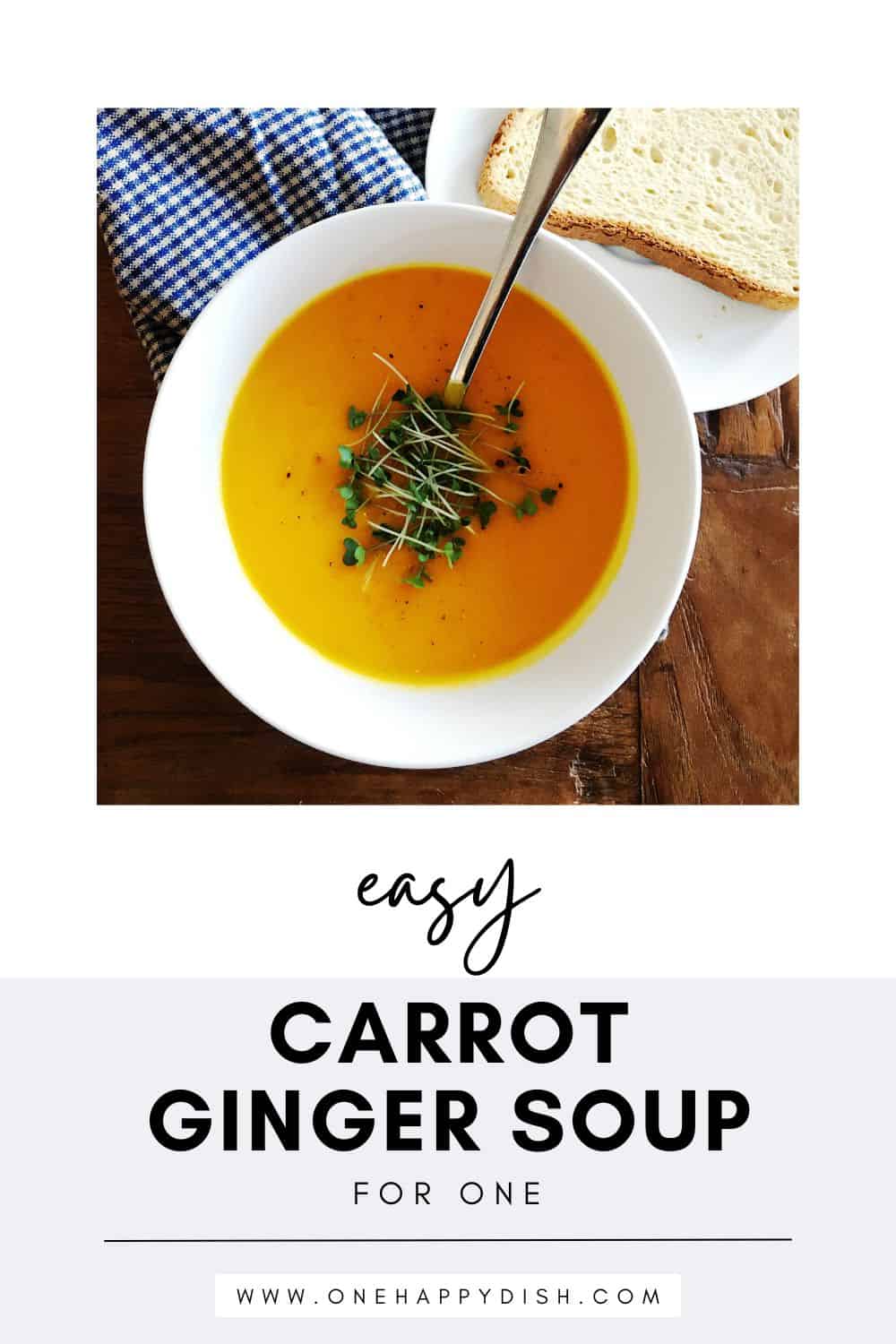 Carrot ginger soup topped with microgreens in a white bowl.