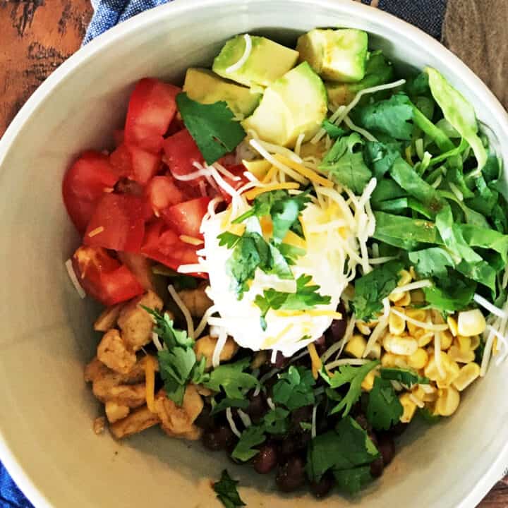 Chicken burrito bowl with a blue and tan striped napkin.
