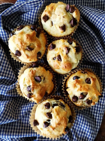 Chocolate chip muffins on a blue and tan plaid napkin.