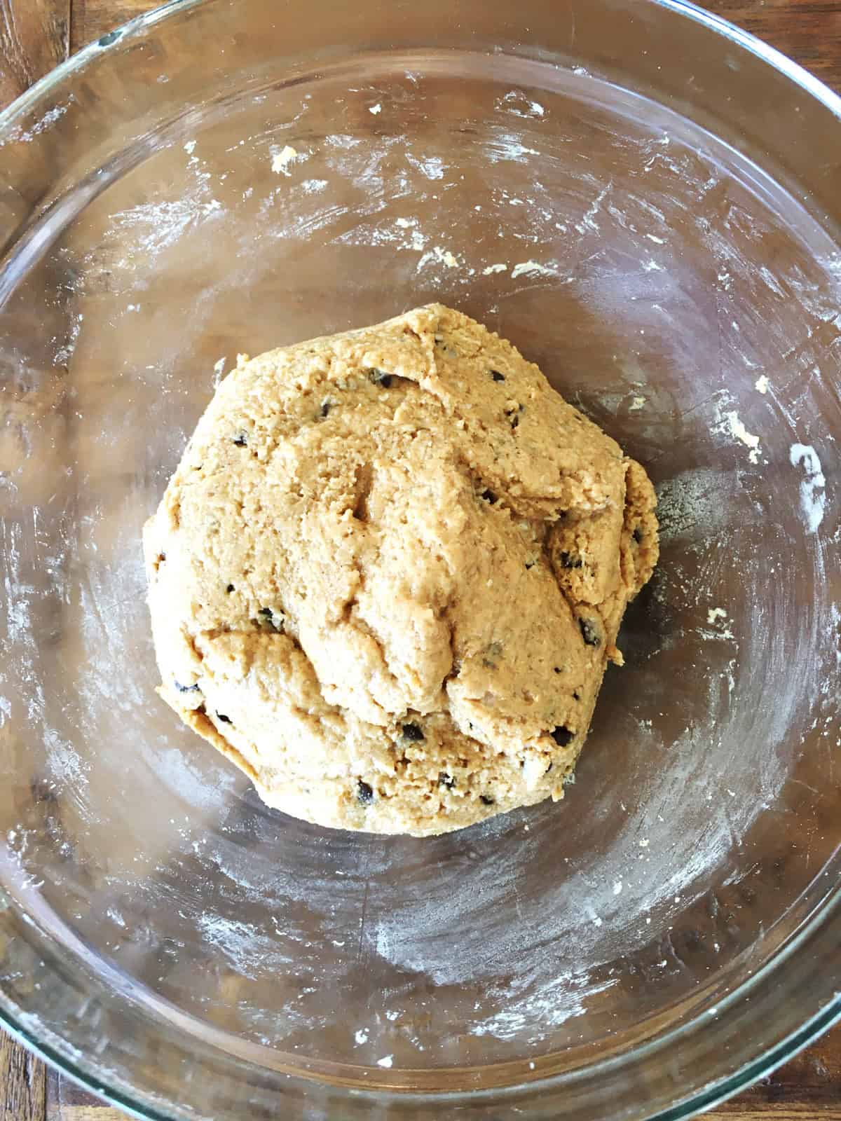 Chilled protein ball batter in a glass bowl on a brown wood table