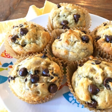 Six banana chocolate chip muffins in paper liners.