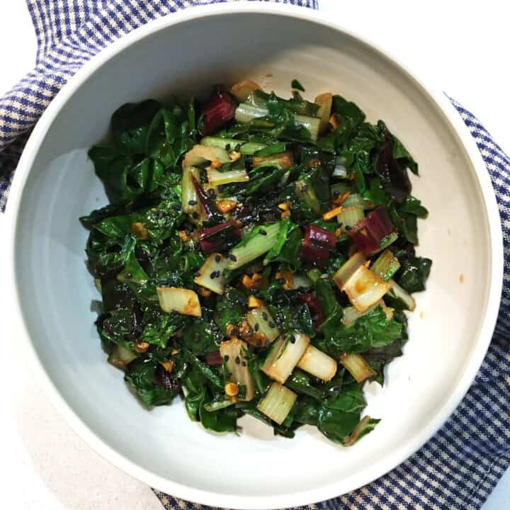 Asian sautéed Swiss chard in a tan ceramic bowl.