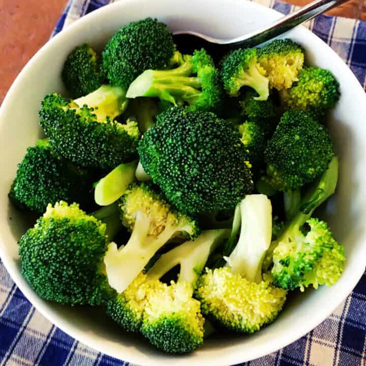 Steamed broccoli in a white bowl.