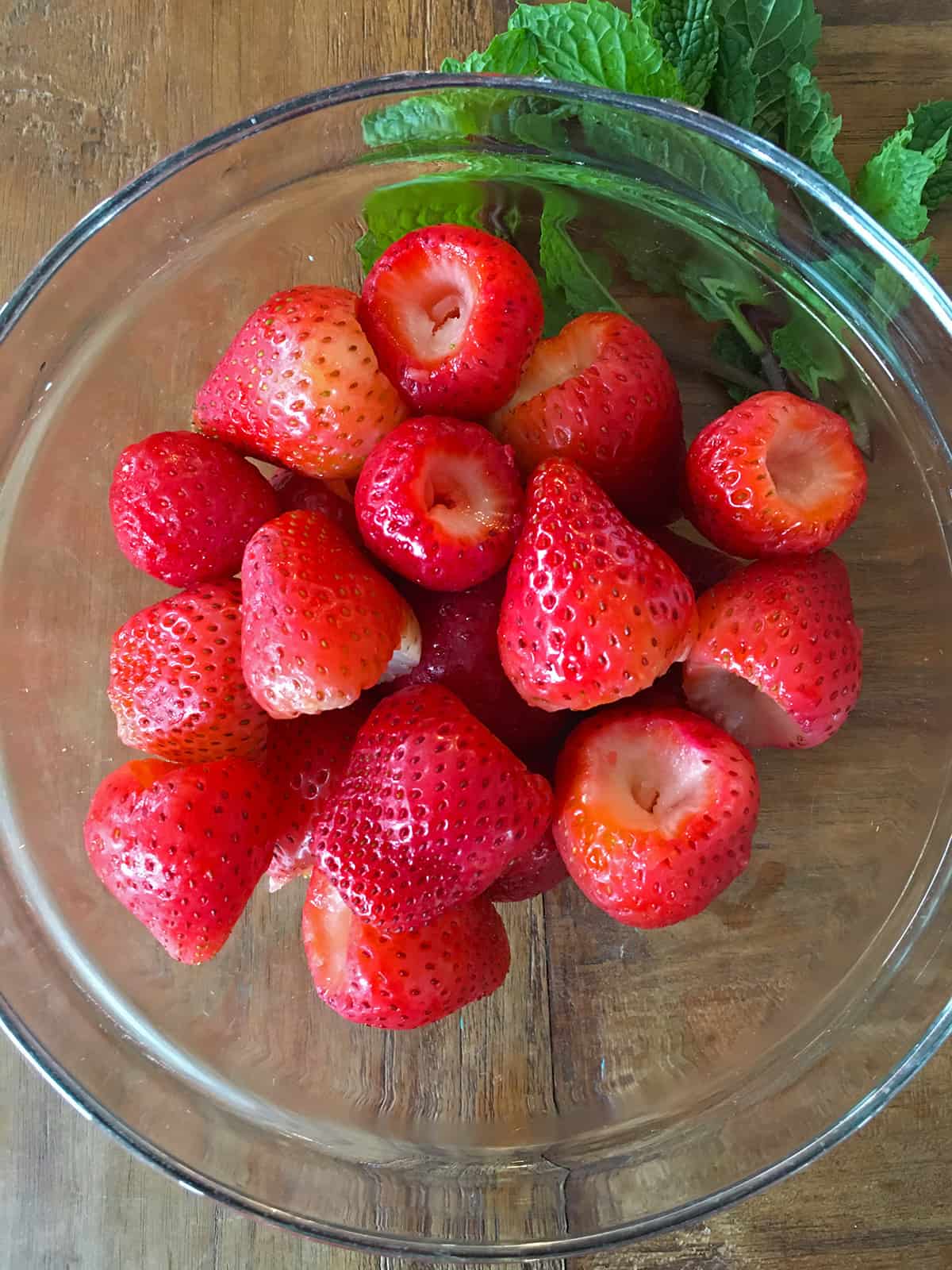 Washed and trimmed fresh strawberries in a glass mixing bowl