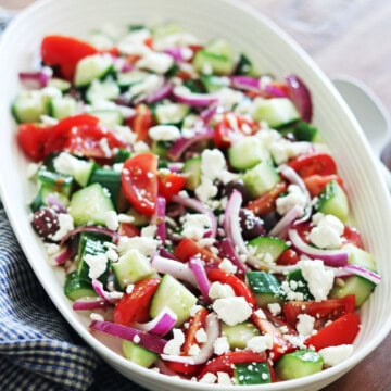 Greek salad on a ceramic beige platter.