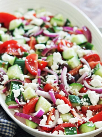 Greek salad on a ceramic beige platter.