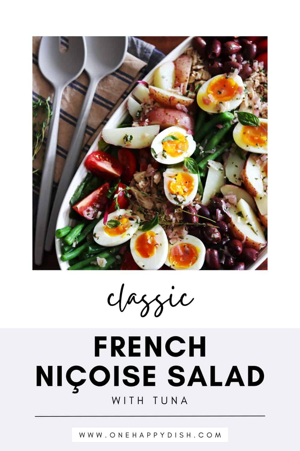 Homemade Niçoise salad in a ceramic beige serving platter.