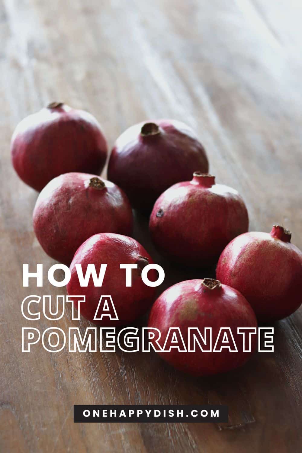 Group of pomegranates on a brown wood table.
