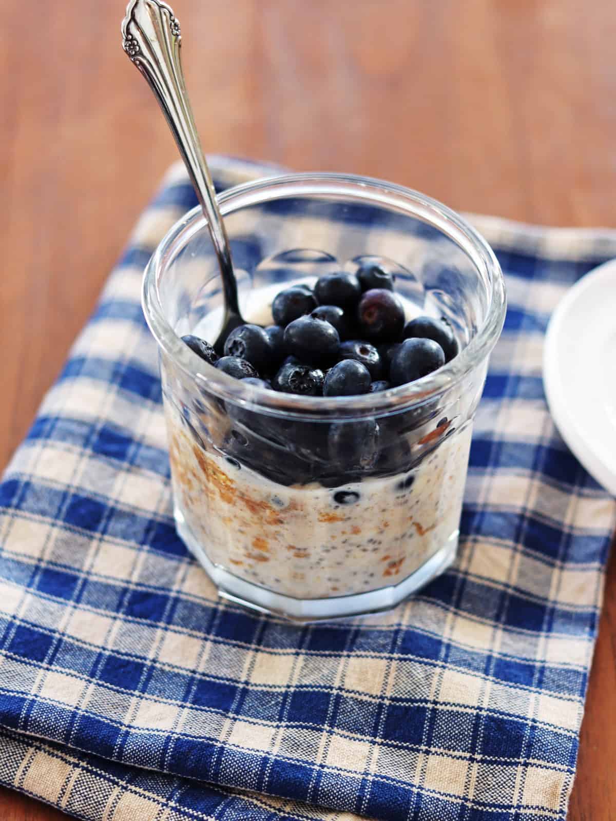 Overnight oats topped with fresh blueberries in a glass working jar.