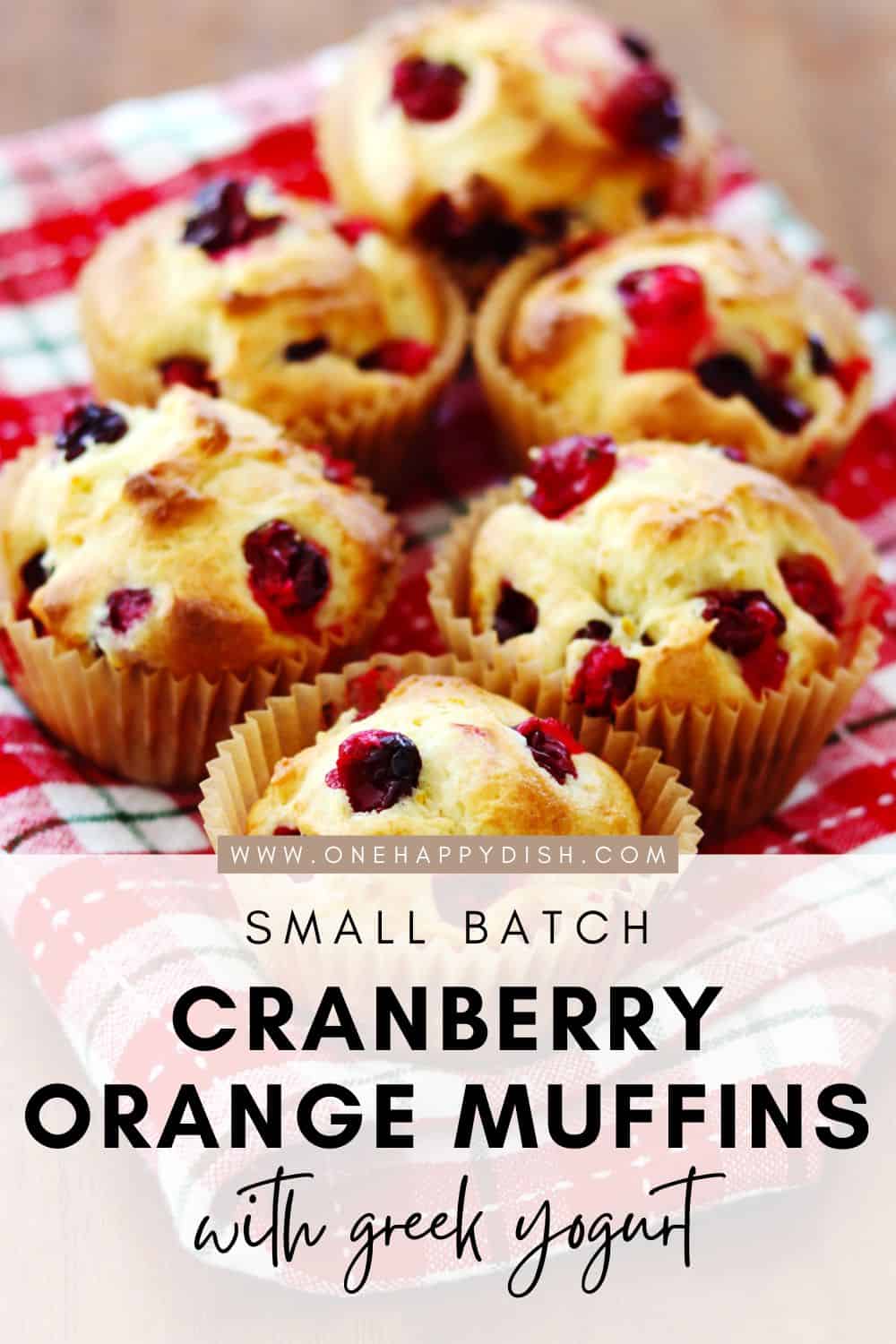 Homemade cranberry orange muffins on a red and white plaid napkin.