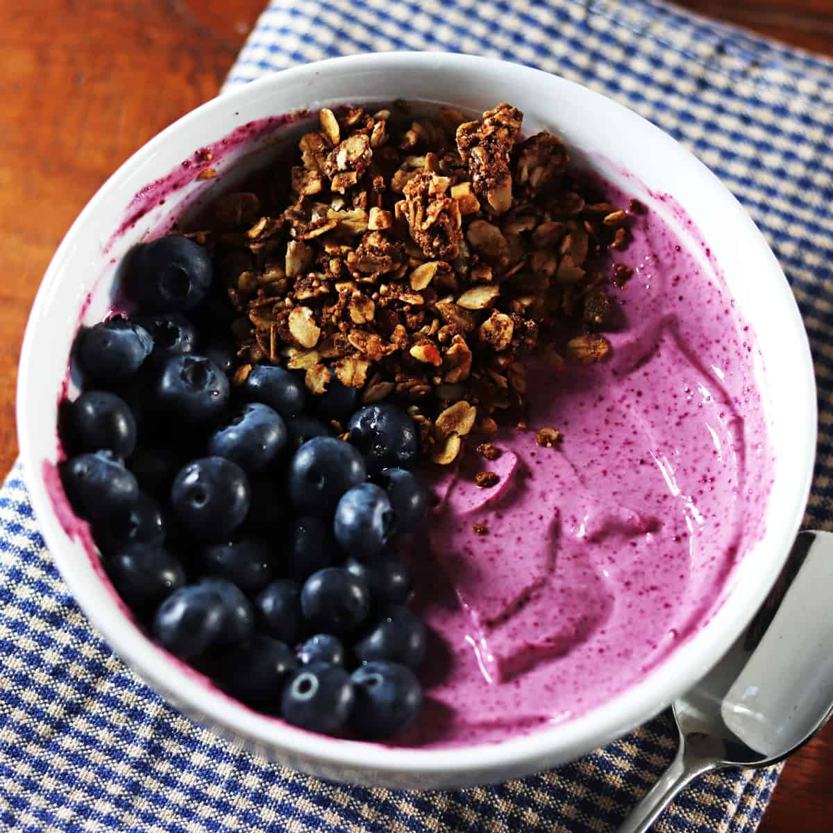 Black raspberry yogurt bowl topped with blueberries and granola.