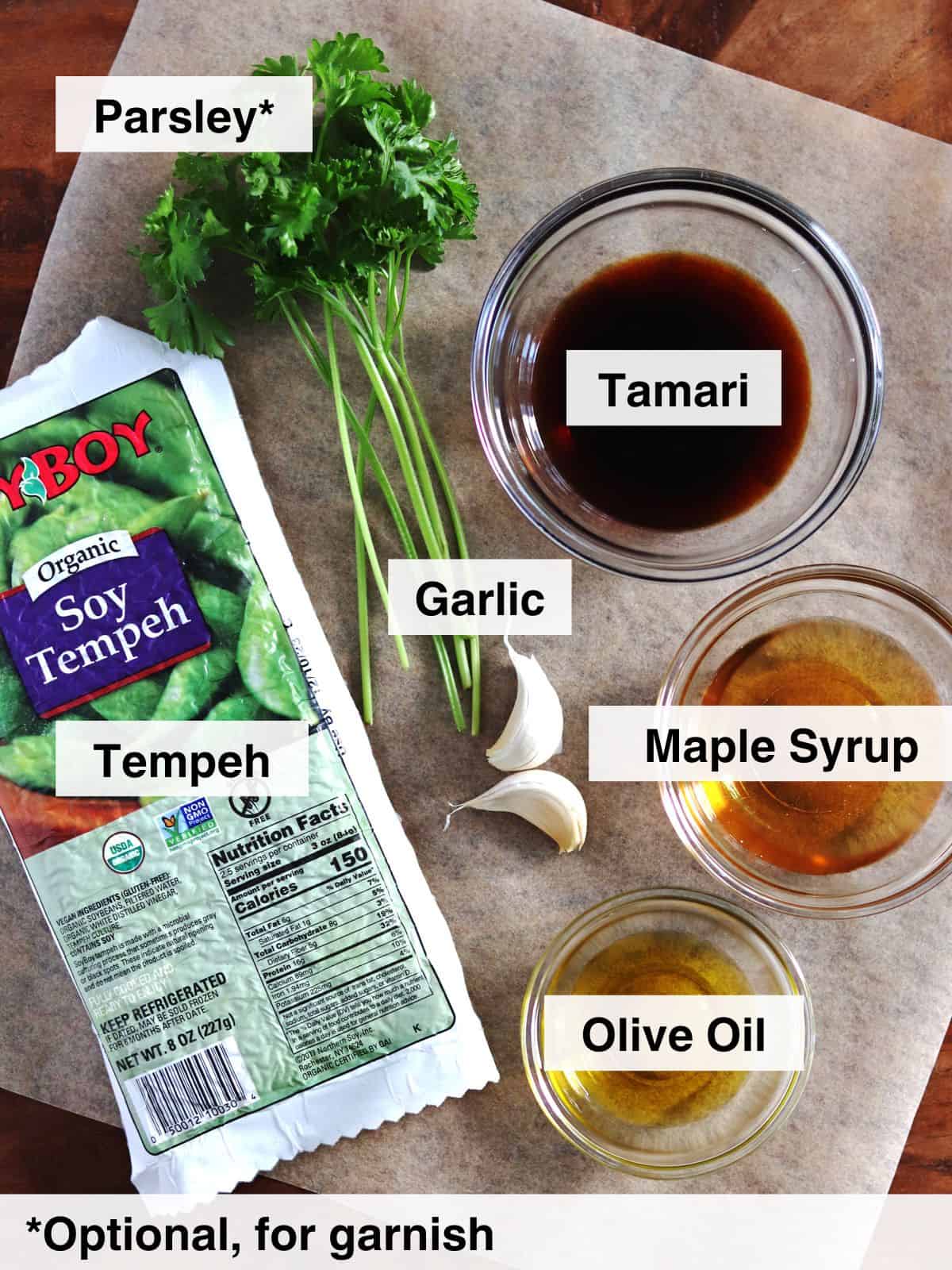 Ingredients for marinated baked tempeh arranged on parchment paper.