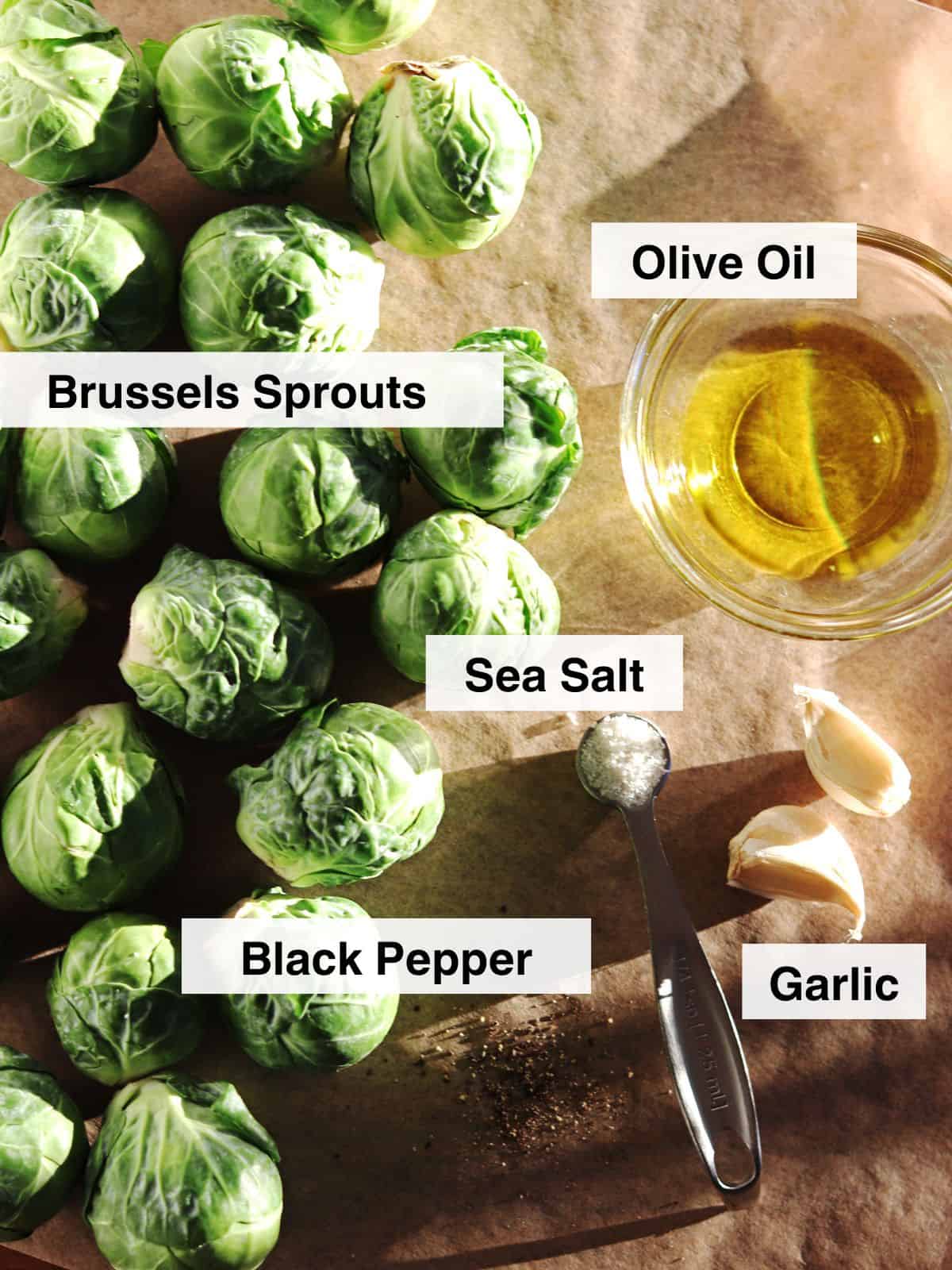 Ingredients for roasted Brussels sprouts arranged on a parchment paper lined table.