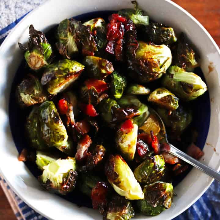 Roasted Brussels sprouts and bacon in a ceramic bowl.