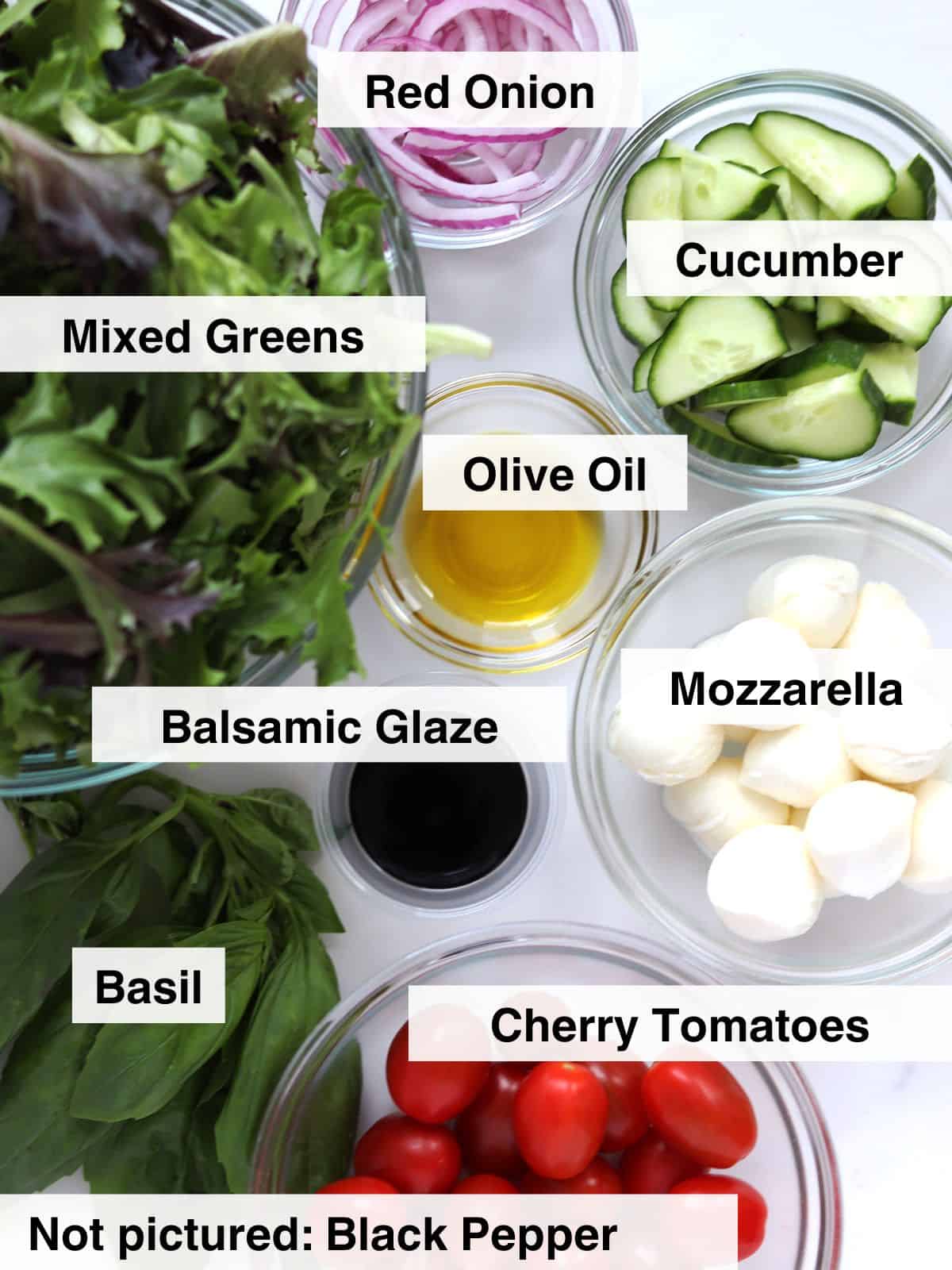 Ingredients for Caprese chopped salad arranged on a white marble countertop.