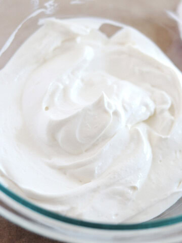 Whipped Greek yogurt in a glass mixing bowl.