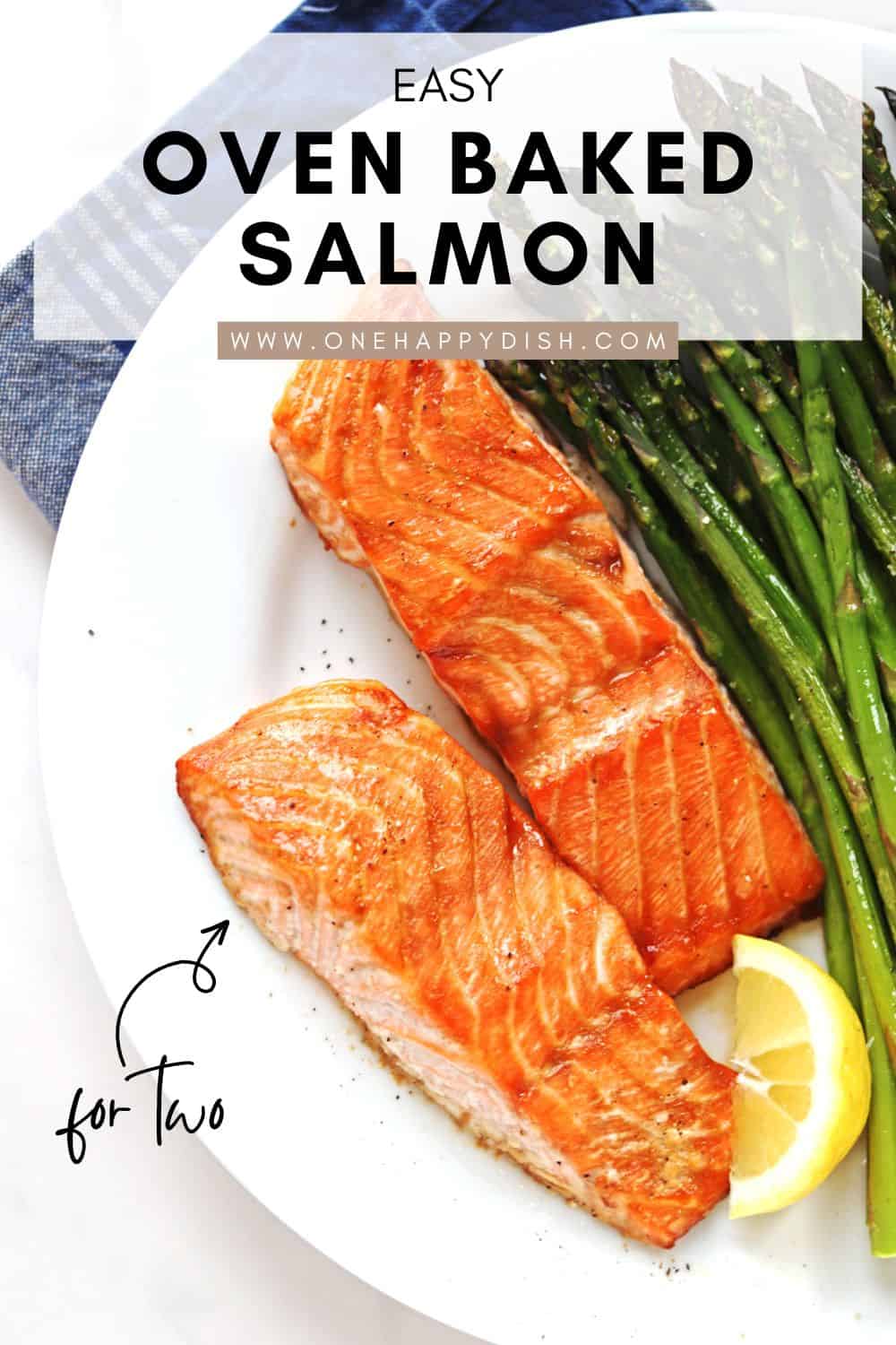 Oven baked salmon fillets on a white plate with a side of asparagus.