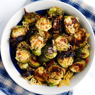 Parmesan crusted Brussels sprouts in a tan ceramic bowl.