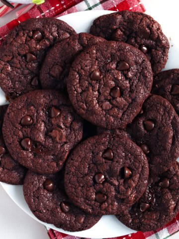 Triple chocolate cookies on a white serving plate.