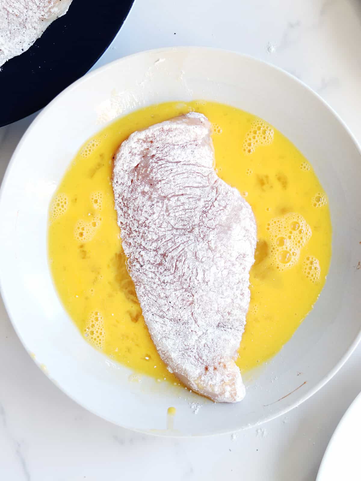 Floured chicken breast dipped in an egg mixture.