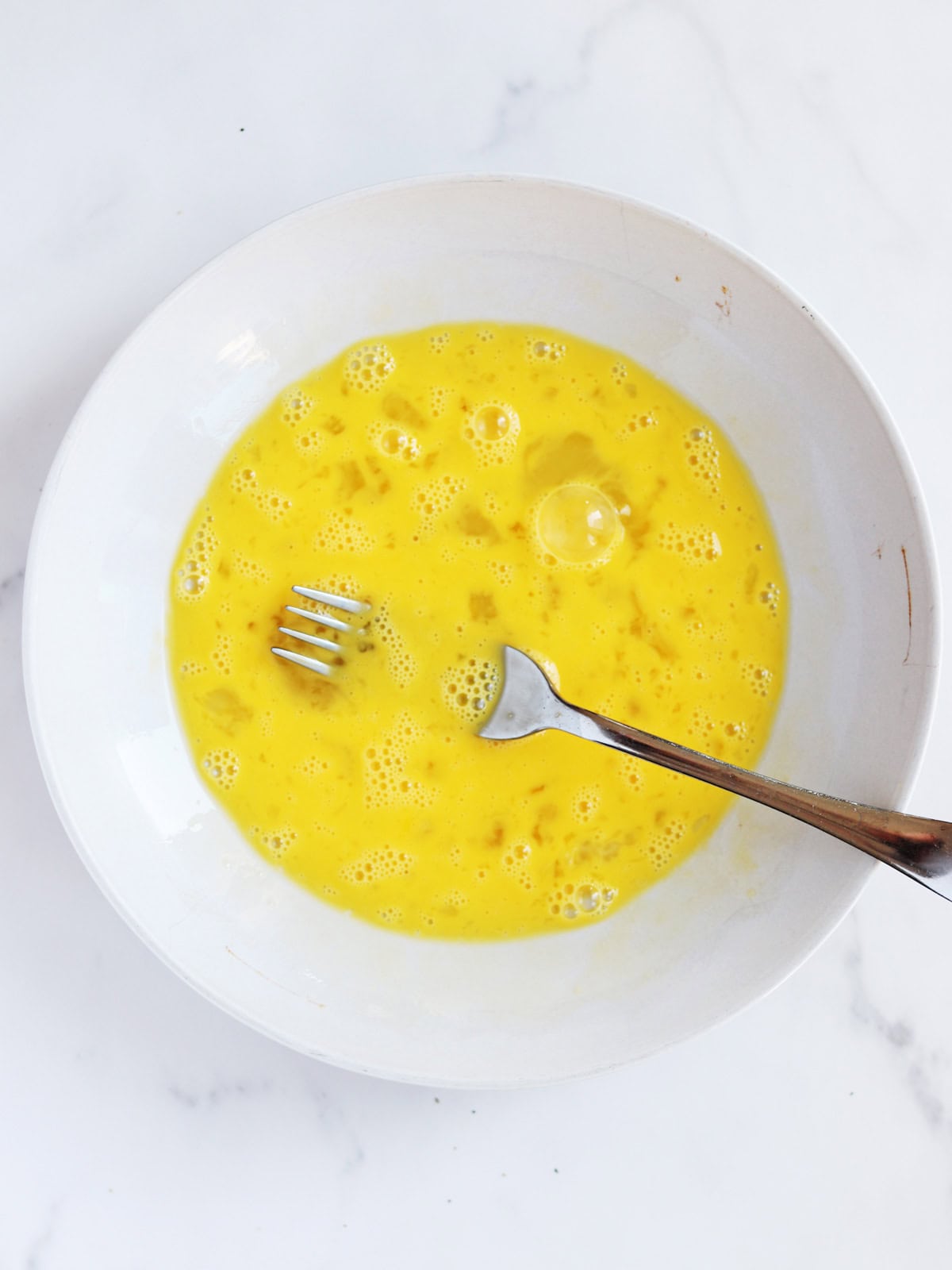 Whisked egg mixture with a fork.