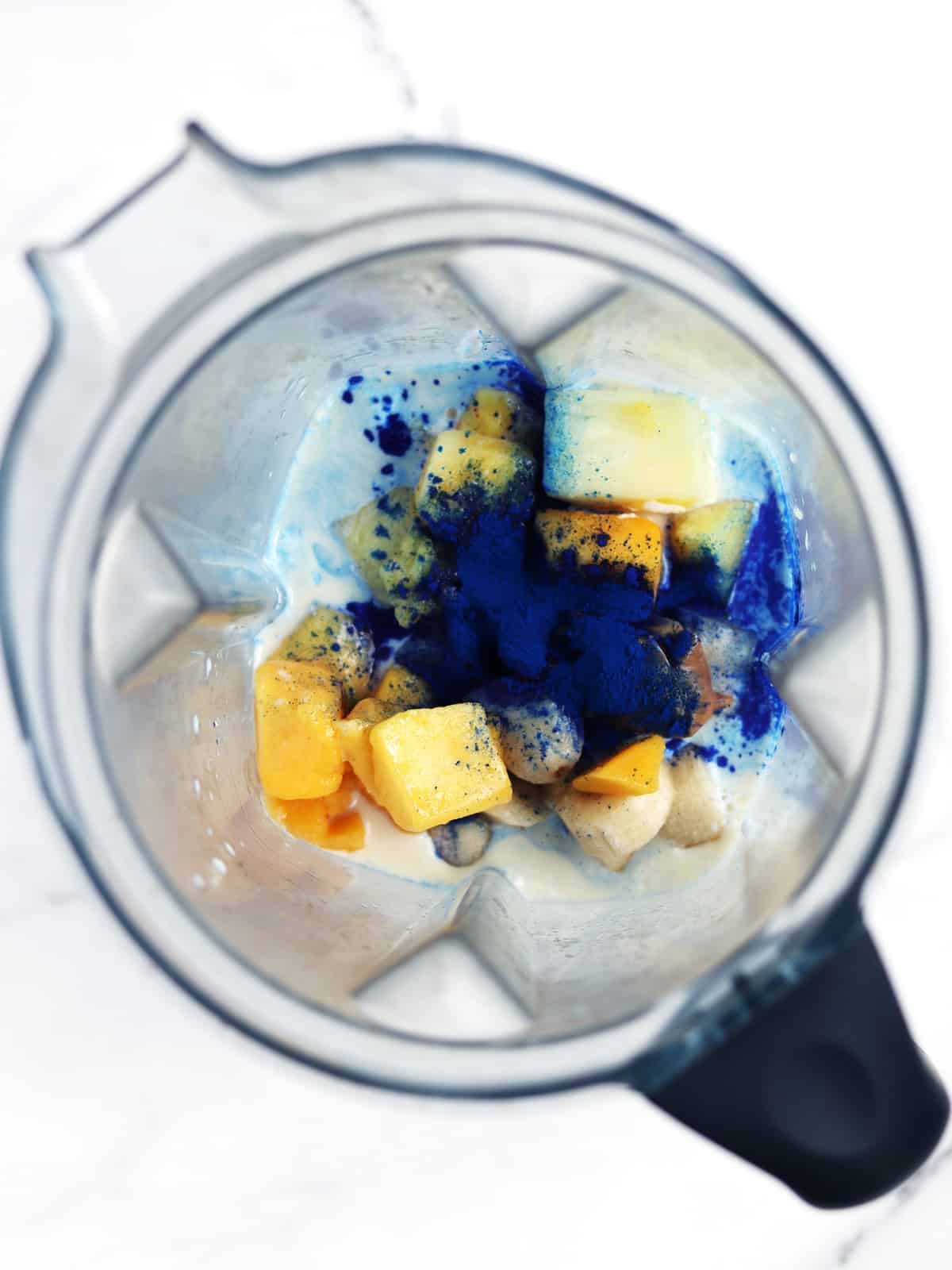 Blue smoothie ingredients in a blender.