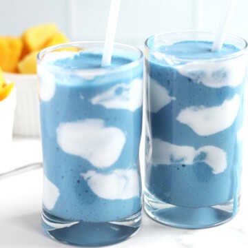 Two blue smoothies with coconut yogurt clouds.