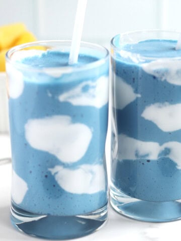 Two blue smoothies with coconut yogurt clouds.