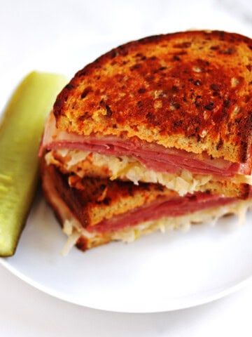 Closeup photo of two halves of a Reuben sandwich.