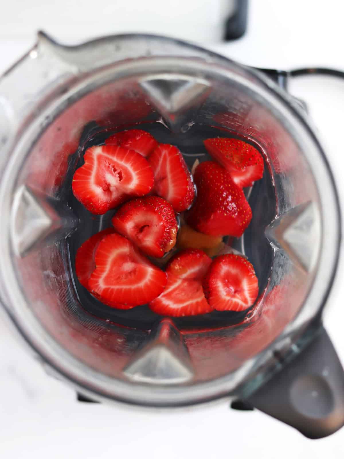 Hulled strawberries, honey and water in a high speed blender.