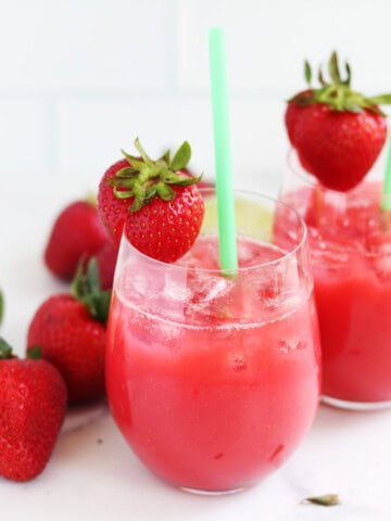 Two strawberry aguas frescas with straws.
