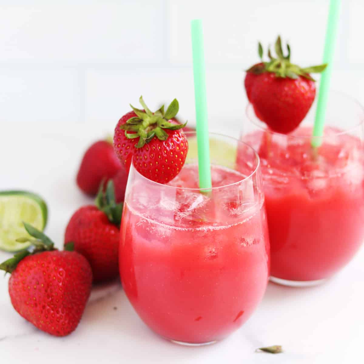 Two strawberry aguas frescas with straws.