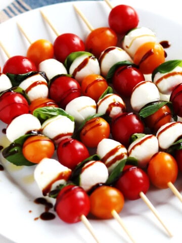 Caprese skewers on a white plate.