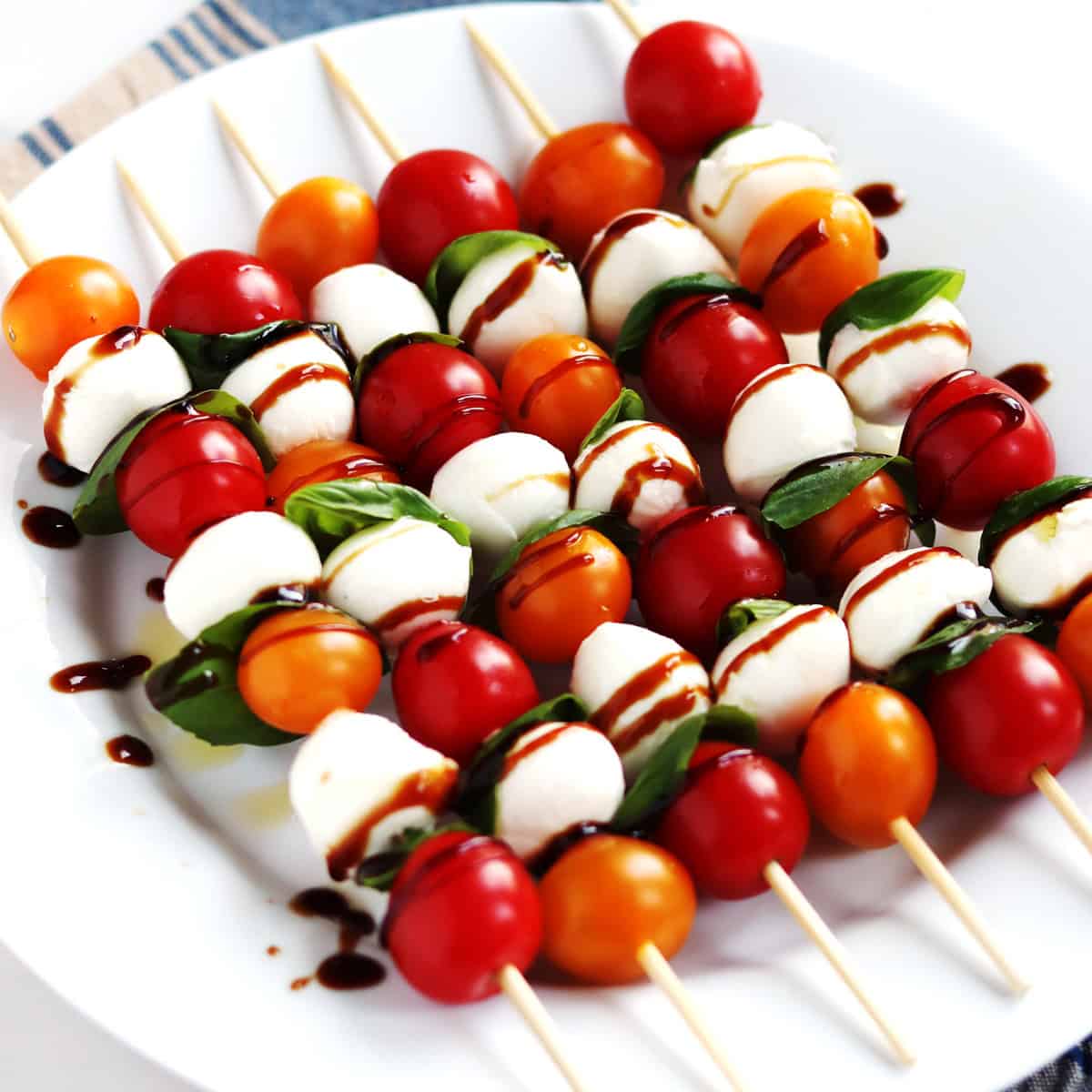 Caprese skewers on a white plate.