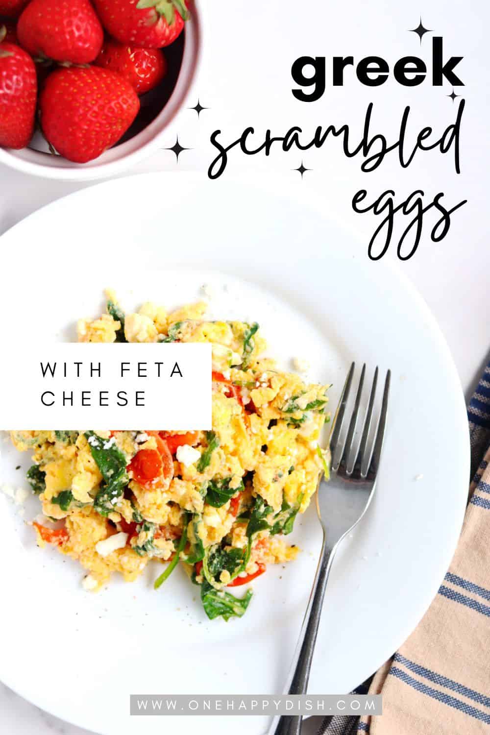 Greek scrambled eggs with a bowl of strawberries.