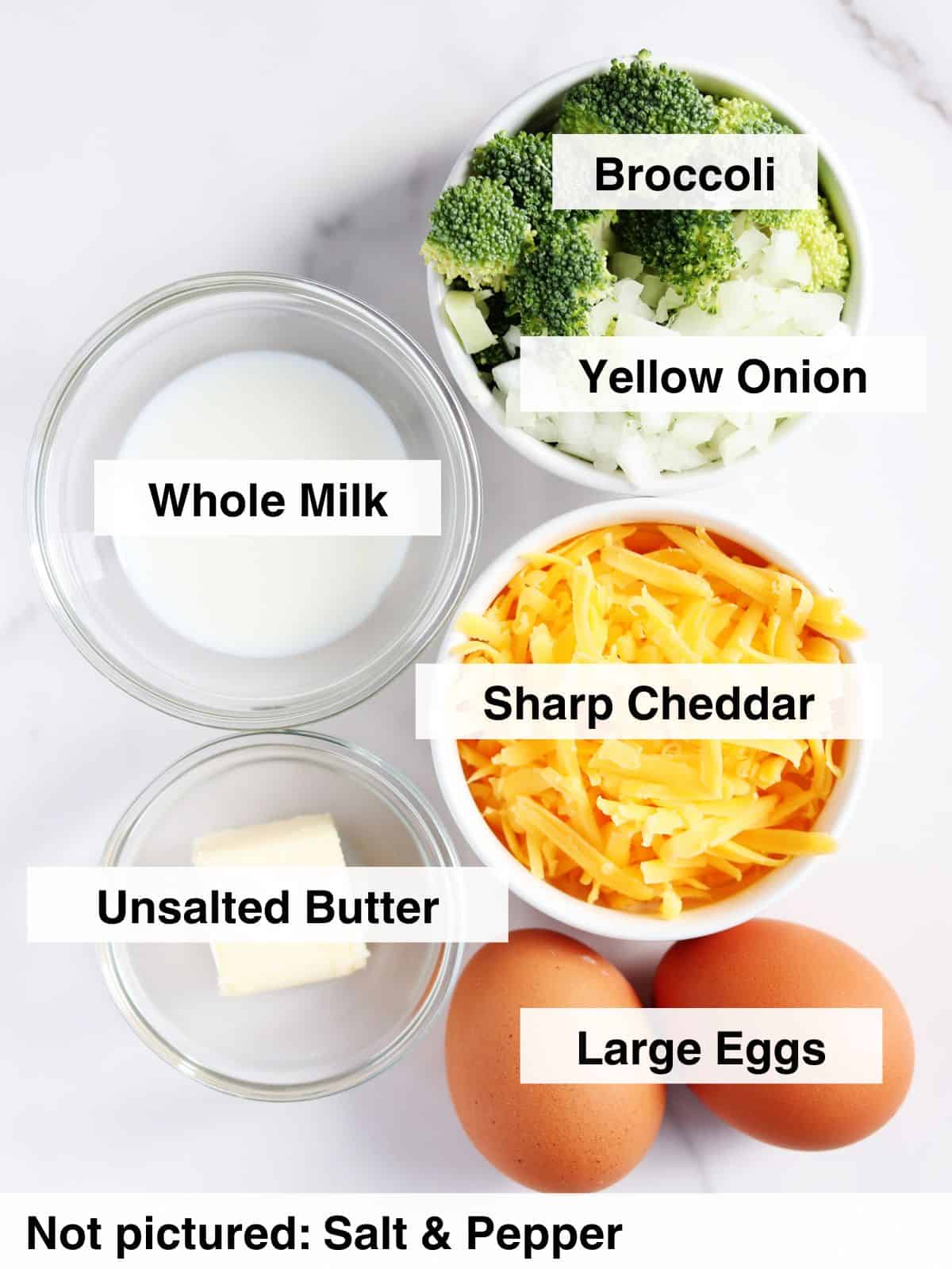 Overhead view of labeled ingredients on a white surface: broccoli, yellow onion, whole milk, sharp cheddar cheese, unsalted butter, and large eggs. Text notes that salt and pepper are not pictured.