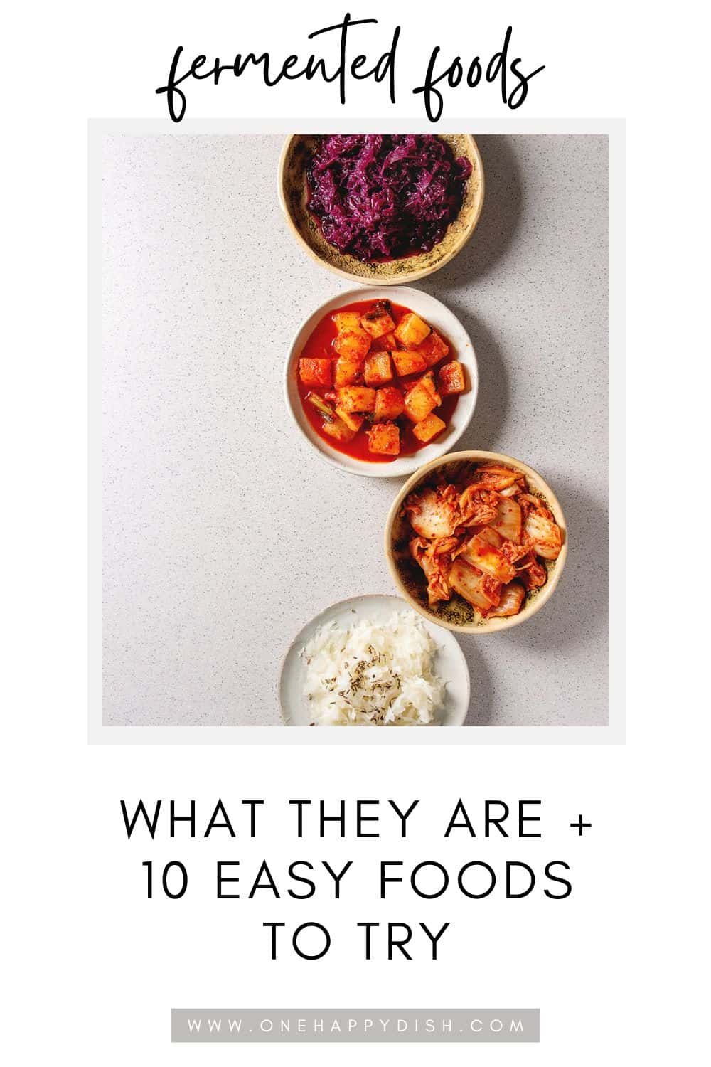 Four bowls of fermented foods, including purple sauerkraut, cubed pickled radish, kimchi, and yogurt, arranged vertically on a white surface with text "fermented foods - what they are + 10 easy foods to try".
