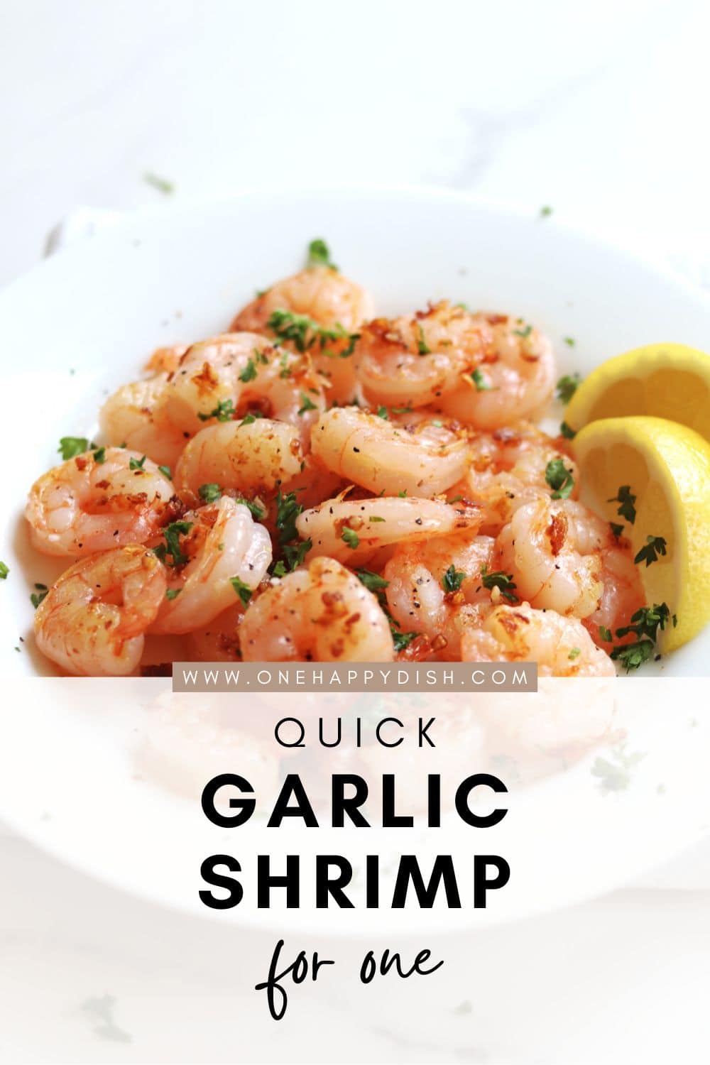 A white plate with seasoned garlic shrimp garnished with parsley and two lemon wedges on the side. Text on the image reads, “Quick Garlic Shrimp for One - www.onehappydish.com”.