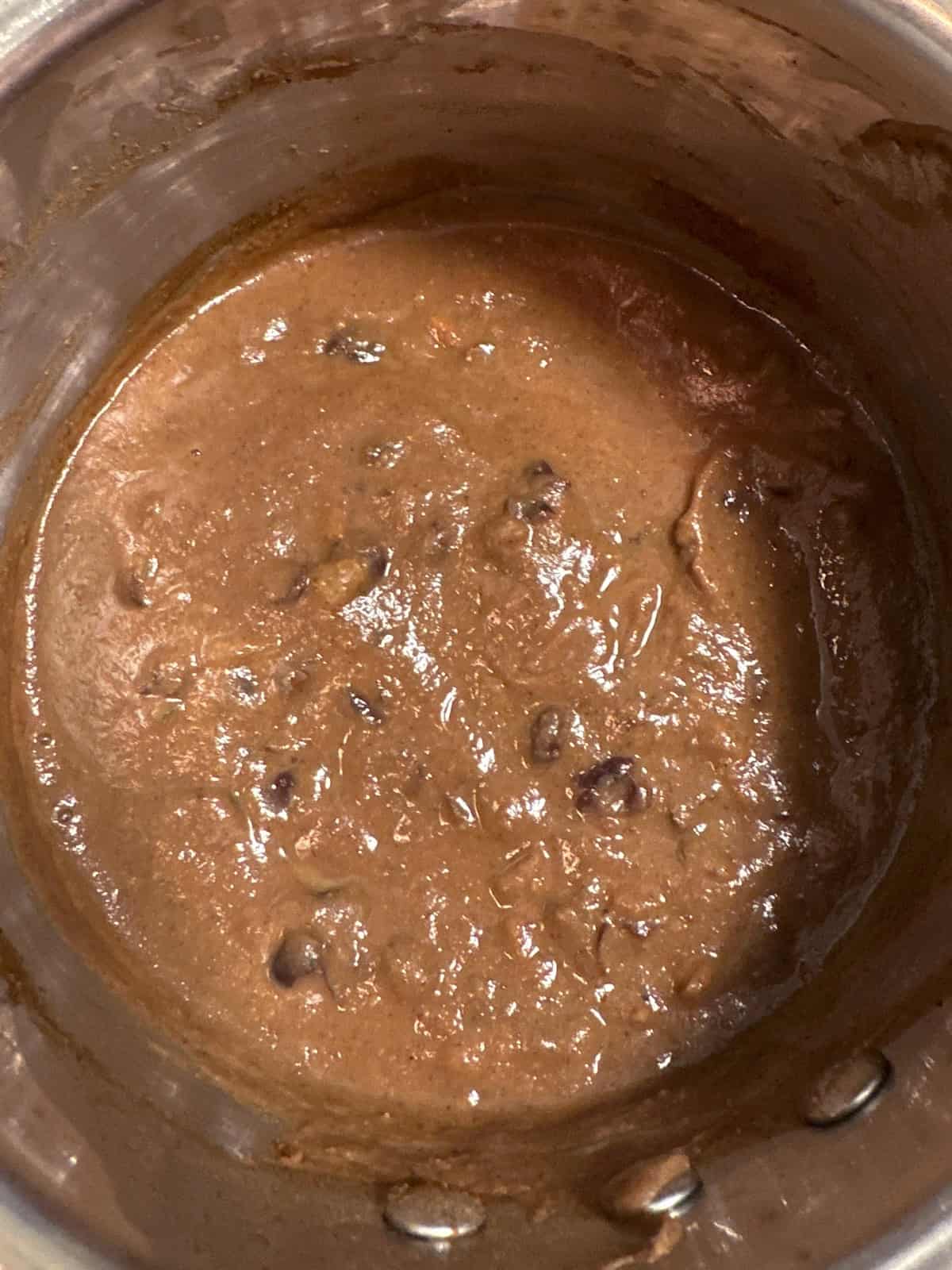 Partially blended black bean soup in a pot.